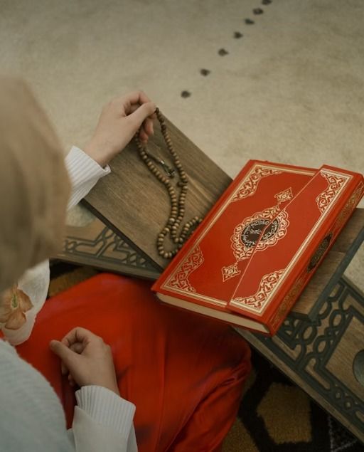 A woman reading the Quran on a wooden stand